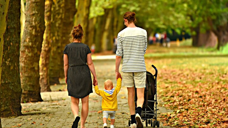 Eltern halten ihr Kind an den Händen fest beim Spaziergang | © pixabay