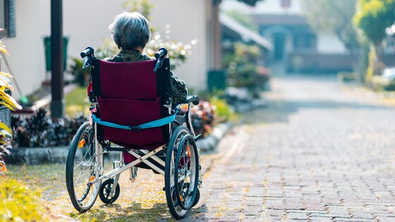 Eine ältere Frau sitzt im Rollstuhl im Garten | © unsplash