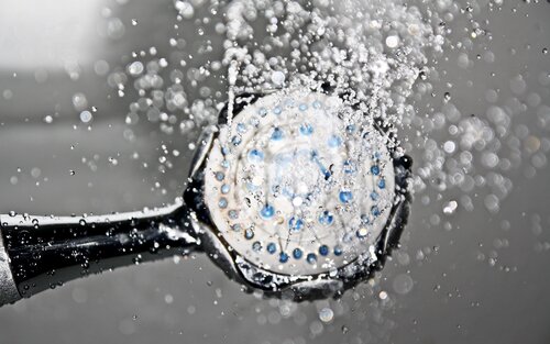 Eine Duschbrause, aus der Wasser spritzt | © pixabay