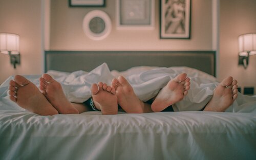 Drei Menschen liegen im Bett | © Ham Kris/unsplash
