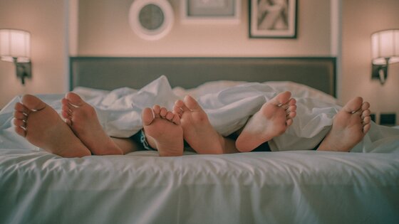 Drei Menschen liegen im Bett | © Ham Kris/unsplash