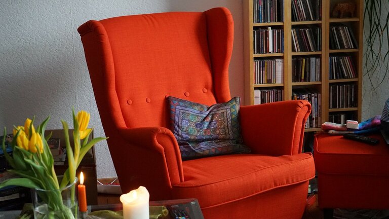 Wohnzimmerecke mit rotem Ohrensessel, Beistelltisch und Bücherregel | © pixabay