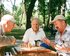 Drei ältere Männer sitzen in einem Park um ein Schachbrett. | © unslapsh