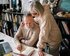 Ein älteres Ehepaar sitzt an einem Schreibtisch und macht sich Notizen in einem Buch | © pexels