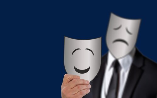 Bild von einem Mann, der eine traurige Maske vor dem Gesicht hält und eine fröhliche Maske in der Hand. | © Pixabay