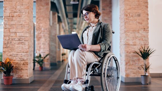 Eine Frau im Rollstuhl mit Laptop in den Händen | ©  Marcus Aurelius /pexels.com