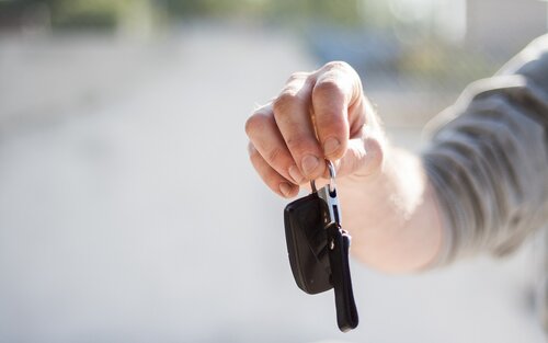 Eine männliche Hand hält einen schwarzen Autoschlüssel zwischen den Fingern und zeigt diesen in die Kamera. | © Pixabay