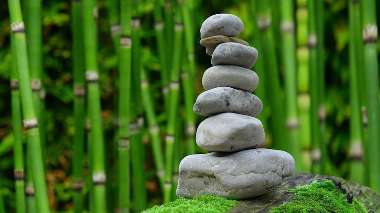 gestapelte Steine vor Bambusstäben | © pixabay