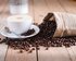 Kaffeebohnen und eine Kaffeetasse liegen auf einem Holztisch. | © Mike Kenneally/unsplash