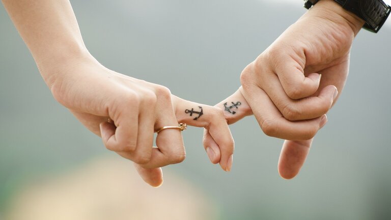Ein Paar zeigt ihre Verbindung durch zwei Finger, die sich kreuzen. | © Pixabay