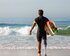 Ein Mann mit einer Oberschenkelprothese auf der rechten Seite läuft mit seinem Surfbrett unter dem Arm ins Meer.  | © pexels.com