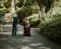 Ein Paar geht im Park spazieren, die Frau sitzt im Rollstuhl. | © Unsplash/ Annie Spratt
