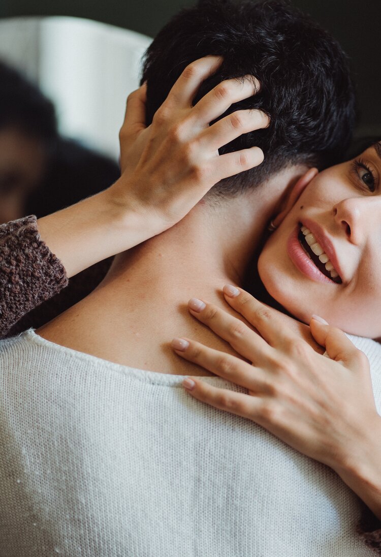 Eine Frau umarmt einen Mann und lächelt. | © Pexels / Ketut Subiyanto