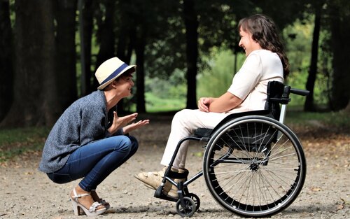 Eine Frau kniet vor einer Frau im Rollstuhl. | © Pexels / Judita Tamosiunaite