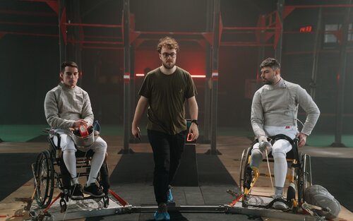 links und rechts sind zwei männliche Rollstuhlfechter, in der Mitte steht ein Mann. | © pexels.com