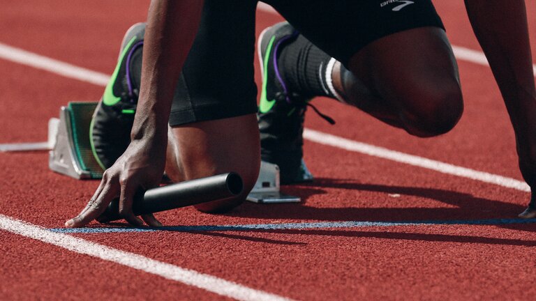 Foto von den Füßen eines Läufers, der sich auf der Startposition befindet. | © Unsplash
