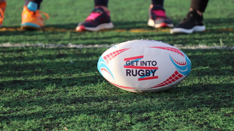 Foto von einem Rugby-Ball, der auf einer Spielfeld-Wiese liegt. | © Unsplash